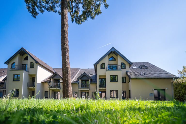 Grüne Parkanlage mit Spazierwegen rund um die Rheinpark Residenz in Unkel